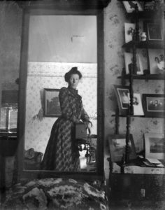unidentified_woman_taking_her_own_photograph_using_a_mirror_and_a_box_camera_roughly_1900-236x300
